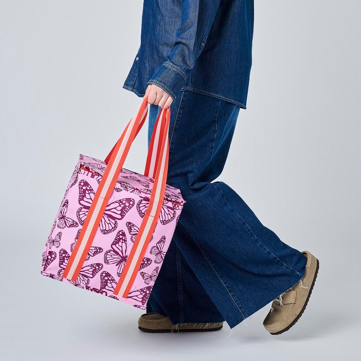 Someone holding the Medium Insulated Tote in Butterfly, using the soft woven handles.
- Project Ten