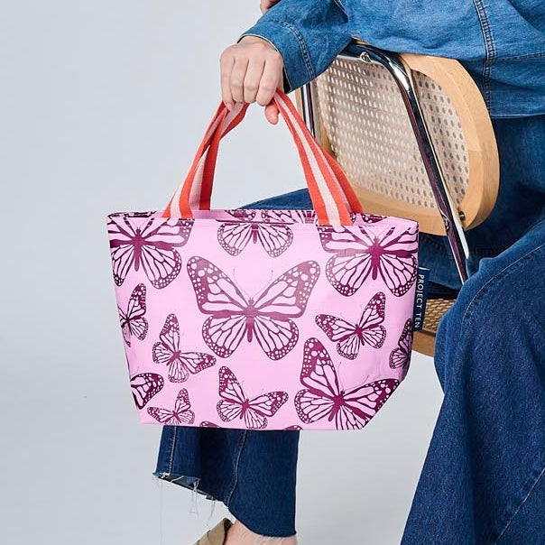 Someone sitting on a chair holding the Mini Tote in the Butterfly pattern.
- Project Ten