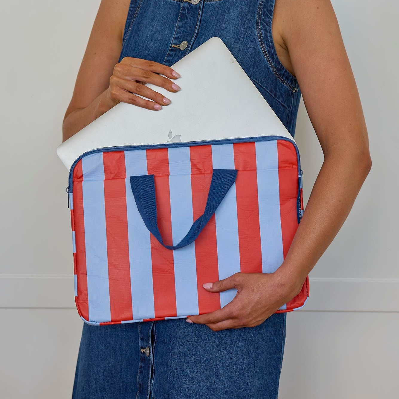 Someone putting a laptop into a Laptop Case – Red Blue Stripe - Project Ten