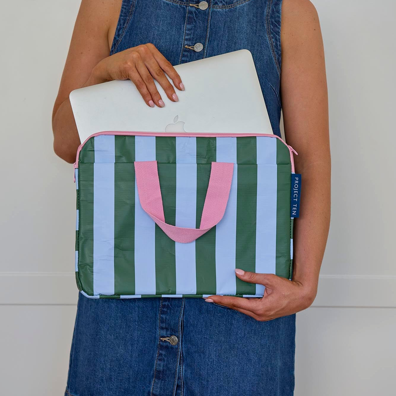 Someone placing a laptop into the Laptop Case – Green Blue Stripe - Project Ten