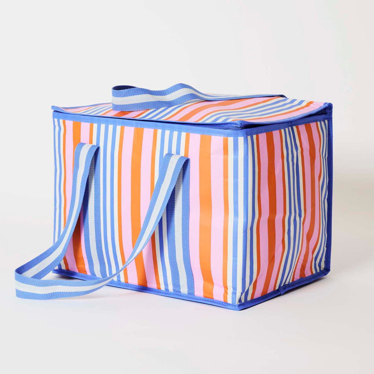 Our Capri Stripe Large Insulated Tote, a large boxy cooler bag in vertical stripes of pink, orange, blue and ecru, with a fold-over zip lid, long blue and ecru striped shoulder straps and a short blue and ecru striped top handle.