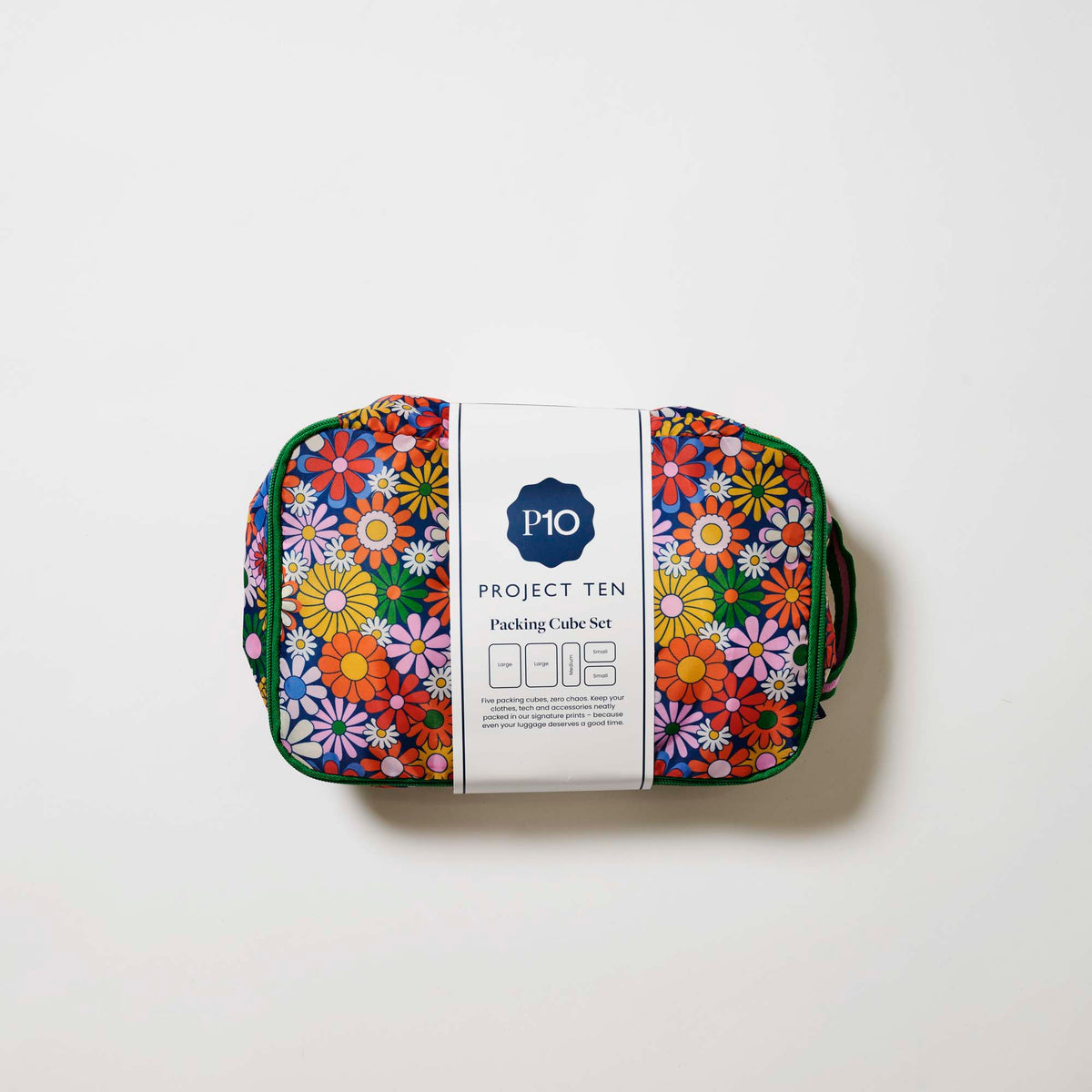 Our Coastal Floral Packing Cubes, a set of five zip-up packing cubes in different sizes, in a retro daisy print of orange, red, pink, yellow, blue and white flowers on a navy background, with green zips and green and pink striped carry handles.