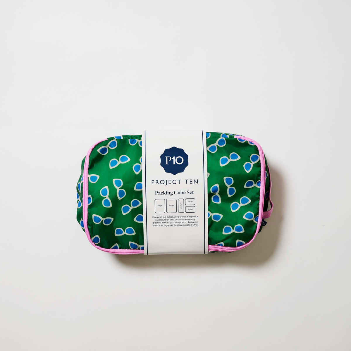 Our Sunglasses Packing Cubes, a set of five zip-up packing cubes in different sizes, in green with a scattered print of blue-lensed, white-framed sunglasses, with pink zips and pink carry handles.