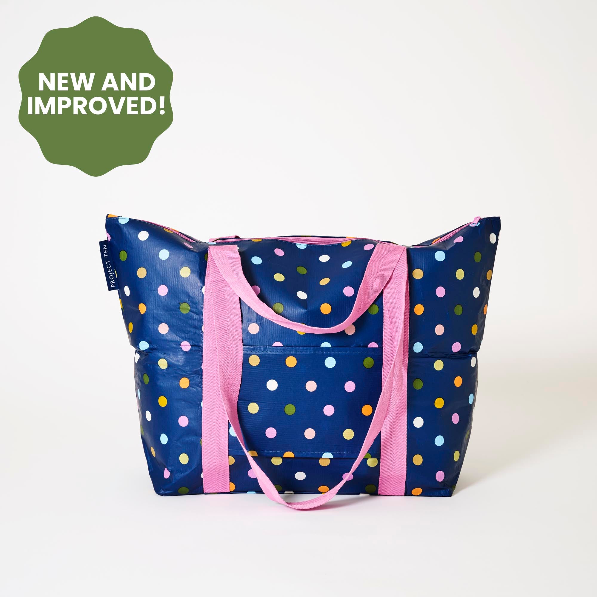 Polka dot tote bag with pink handles on a white background, featuring a 'New and Improved!' label.