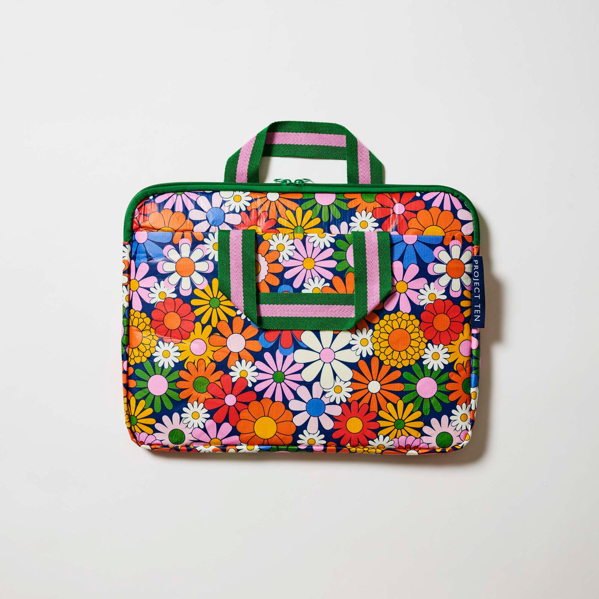 Our Coastal Floral Laptop Case, a slim zip-up laptop case in a retro daisy print of orange, red, pink, yellow, blue and white flowers on a navy background, with two green and pink striped carry handles and a green zip.