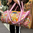 Someone holding the Hydrangea Barrel Bag using the doubles handles 
- Project Ten