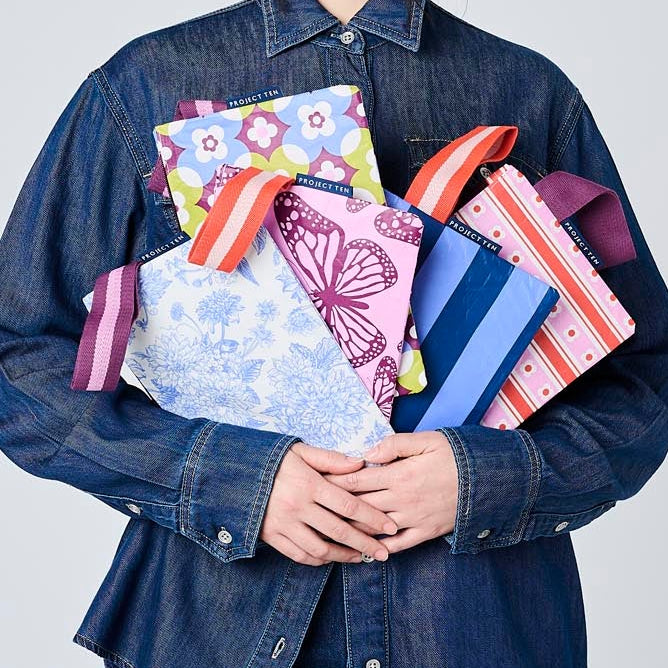 A person holding our Mini Zip Pouches. 
Wallpaper, Butterfly, Toile, Mosaic & Blue Stripe. 
- Project Ten