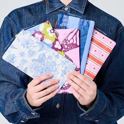 Someone holding 5 Tiny Zip Pouches.
Toile, Mosaic, Butterfly, Blue Stripe & Wallpaper. 
- Project Ten
