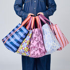Someone holding 5 Shopper Totes in Wallpaper, Butterfly, Toile, Mosaic & Blue Stripe. 
- Project Ten