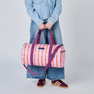 Someone holding our Wallpaper Barrel Bag using the double soft woven handles. 
- Project Ten