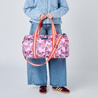 Someone holding the Barrel Bag in Butterfly using the soft woven handles. 
- Project Ten