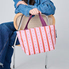 Someone holding the Mini Tote in Wallpaper, using the soft woven handles.
- Project Ten 