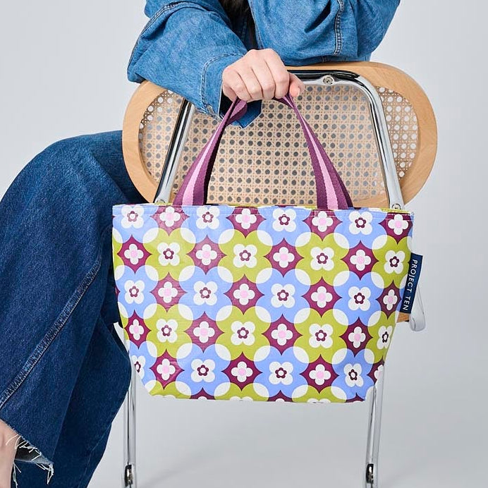 Someone holding the Mini Tote using the soft woven handles. 
- Project Ten