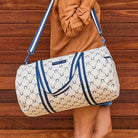 Someone holding our Barrel Bag using the shoulder strap – Navy Horseshoe - Project Ten