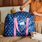 Overnight Bag – Confetti - Project Ten Polka dots on navy background.
Person placing an item into the overnight bag.
