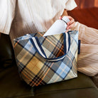 Someone sitting whilst putting their drink bottle into the Mini Tote – Country Plaid - Project Ten