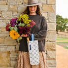 Someone holding flowers and our Wine Bag with a bottle of champagne in it– Navy Horseshoe - Project Ten