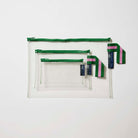 Our Green Clear Zip Pouch Bundle, a set of three clear zip pouches in small, medium and large, with green zips and green and pink striped loop tabs.
