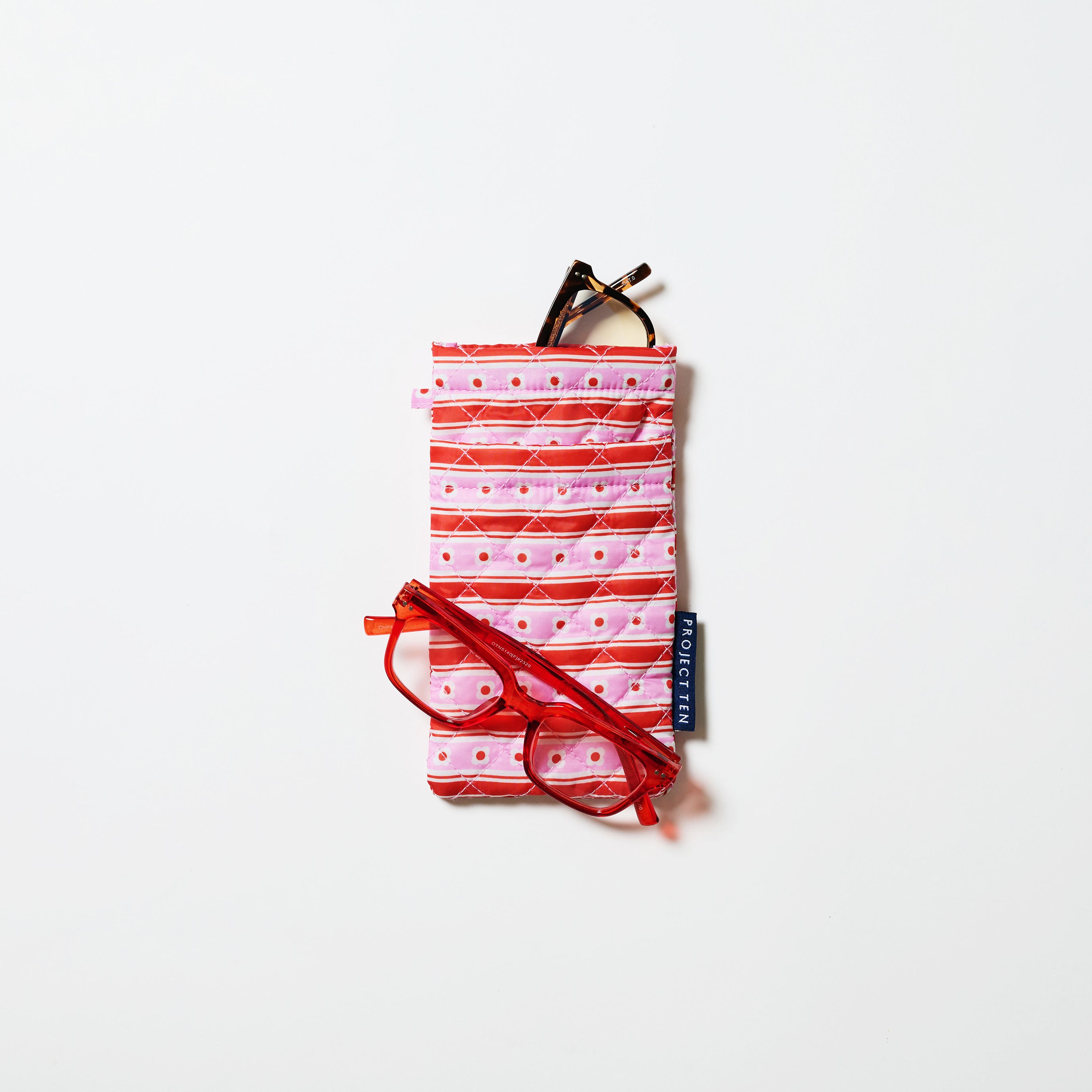 Double Glasses Case in Wallpaper pattern showing reading glasses in the top pocket and another set of reading glasses resting across the glasses holder. 