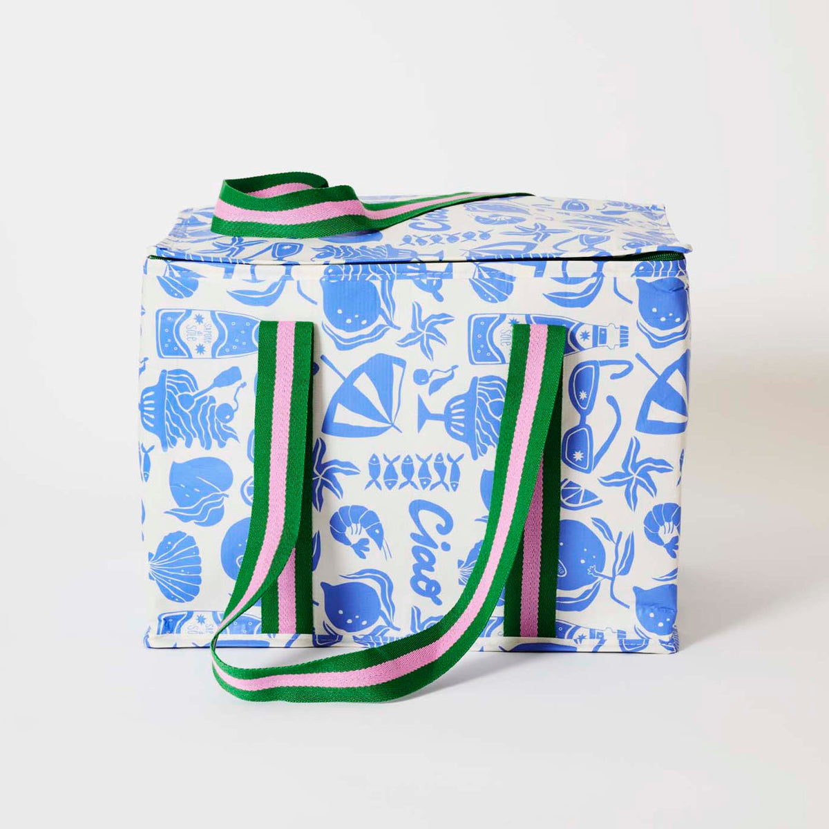 Our Feast Large Insulated Tote, a large boxy cooler bag in a blue and ecru print of shells, beach umbrellas, sunglasses, gelato and the word "Ciao", with a fold-over zip lid, long green and pink striped shoulder straps and a short green and pink striped top handle.