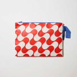 Our Red Ripple Large Zip Pouch, a flat rectangular pouch in a red and ecru wave print with a blue zip and blue handle.