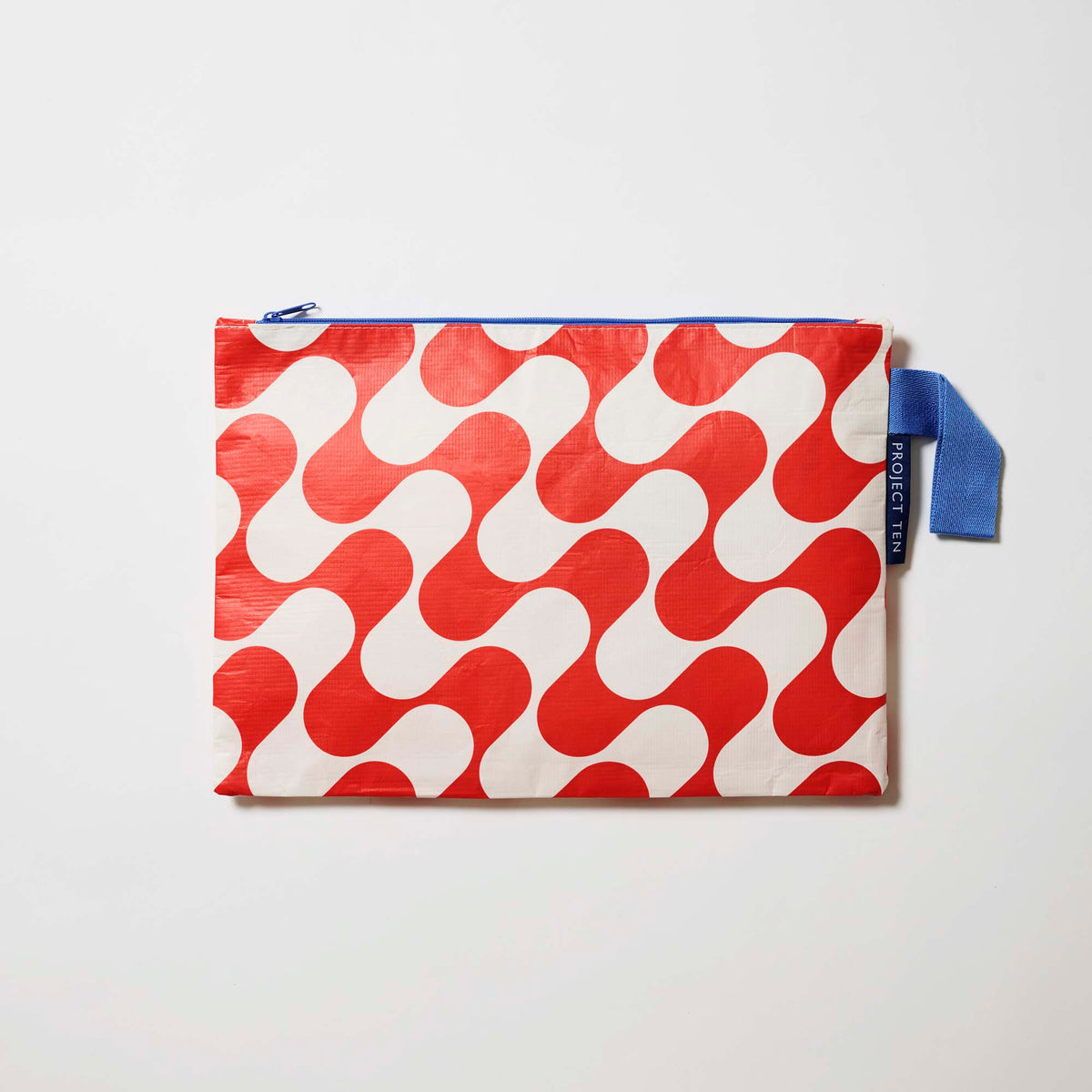 Our Red Ripple Large Zip Pouch, a flat rectangular pouch in a red and ecru wave print with a blue zip and blue handle.