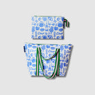 Our Feast Large Zip Pouch and Zip Medium Tote Bundle, a Zip Medium Tote and a matching Large Zip Pouch in an ecru base with a blue seaside print of shells, oranges, sunglasses, ice cream sundaes and "Ciao" lettering, with green and pink striped carry handles and a loop tab.