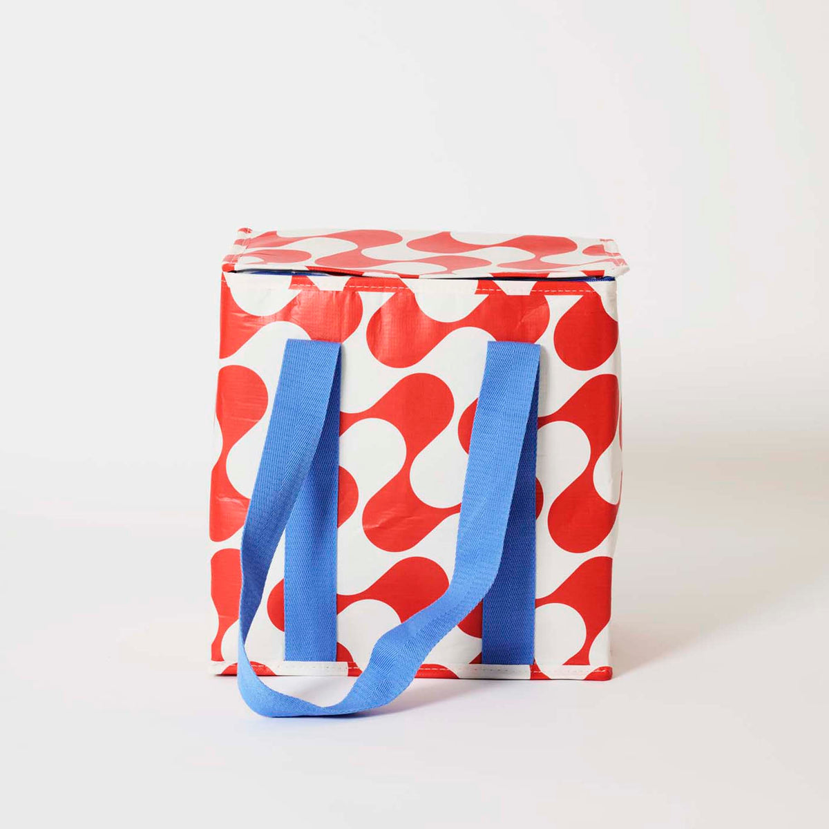 Our Red Ripple Medium Insulated Tote, in a red and ecru wave print with a fold-over zip lid and long blue straps.