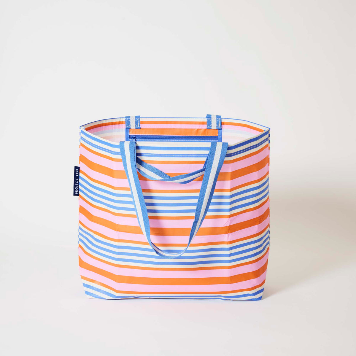 Our Capri Stripe Medium Tote in horizontal stripes of pink, orange, blue and ecru, with blue and ecru striped straps, shown open against a plain background.