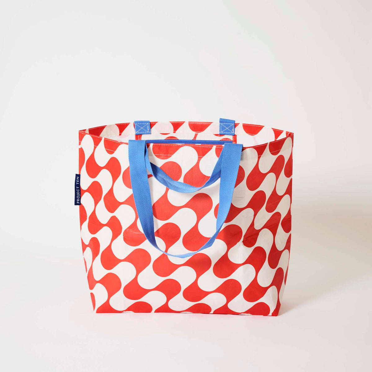 Our Red Ripple Medium Tote in a red and ecru wave print with blue straps, shown open against a plain background.
