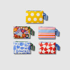 Our Summer 26 Prints Mini Zip Pouch Bundle, a set of five Mini Zip Pouches in Yellow Polka Dot, Coastal Floral, Capri Stripe, Feast and Red Ripple prints, each with a matching loop tab.