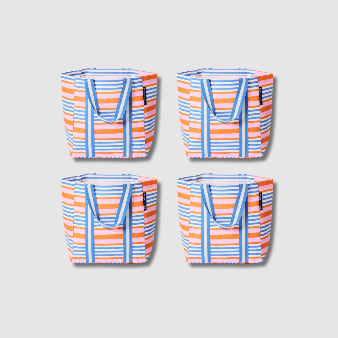 Our Capri Stripe Shopper Tote Bundle, a set of four Shopper Totes in pink, orange, blue and ecru stripes, each with a vertical striped front panel and blue and ecru striped carry handles.