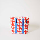Our Red Ripple Shopper Tote in a red and ecru wave print with blue straps that run down the front and back, shown open against a plain background.