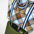 Image shows the new and improved Zip Medium Tote using the luggage band on a suitcase - Project Ten