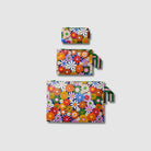 Our Coastal Floral Zip Pouch Bundle, a set of three Zip Pouches in small, medium and large in a retro daisy print of orange, red, pink, yellow, blue and white flowers on a navy background, with green and pink striped loop tabs on the medium and large pouches.