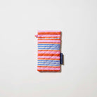 Our Capri Stripe Double Glasses Case, a soft quilted glasses case in pink, orange, blue and ecru horizontal stripes, with a squeeze-top opening and a small loop tab.