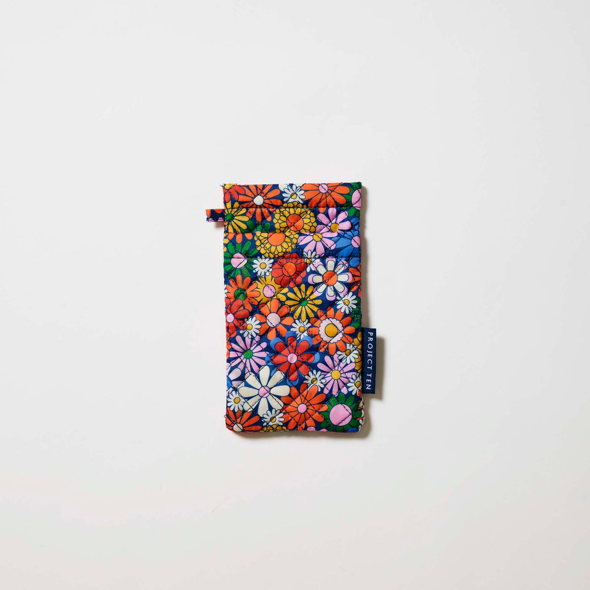 Our Coastal Floral Double Glasses Case, a soft quilted glasses case in a retro daisy print of orange, red, pink, yellow, blue and white flowers on a navy background, with a squeeze-top opening and a small loop tab.