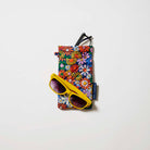 Our Coastal Floral Double Glasses Case, a soft quilted glasses case in a retro daisy print of orange, red, pink, yellow, blue and white flowers on a navy background, with a squeeze-top opening and a small loop tab.