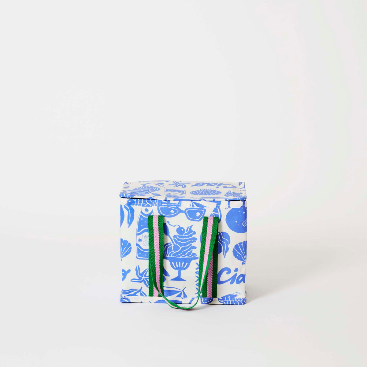 Our Feast Mini Insulated Tote, a small boxy cooler bag in a blue and ecru print of shells, gelato, soda bottles, sunglasses and the word "Ciao", a fold-over zip lid and short green and pink striped carry handles.