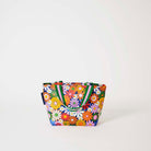 Our Coastal Floral Mini Tote, a compact tote bag in a retro daisy print of orange, red, pink, yellow, blue and white flowers on a navy background, with two green and pink striped carry handles.