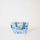 Our Feast Mini Tote, a compact tote bag in an ecru base with a blue seaside print of sunglasses, ice cream sundaes, oranges, shells, sardines and "Ciao" lettering, with two green and pink striped carry handles.