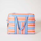 Our Capri Stripe Overnight Bag, a roomy duffle-style bag in pink, orange, blue and ecru stripes, with a vertical striped front pocket, two blue and ecru striped carry handles and a blue zip.