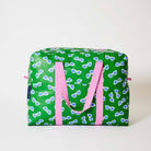 Our Sunglasses Overnight Bag, a roomy duffle-style bag in green with a scattered print of blue-lensed, white-framed sunglasses, two pink carry handles and a pink zip.