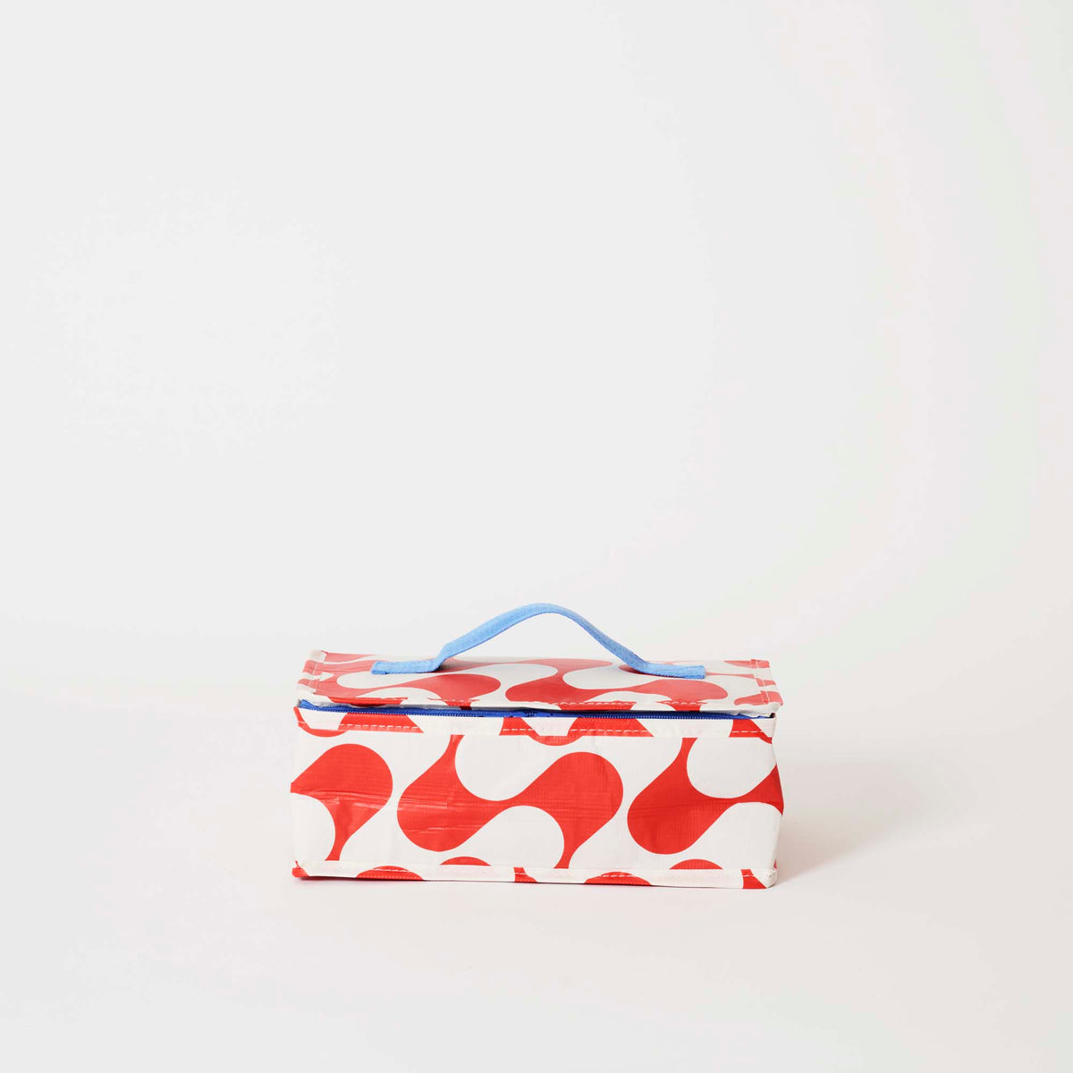 Our Red Ripple Takeaway Bag, a rectangular insulated bag in a red and ecru wave print with a zip closure and a single blue carry handle.