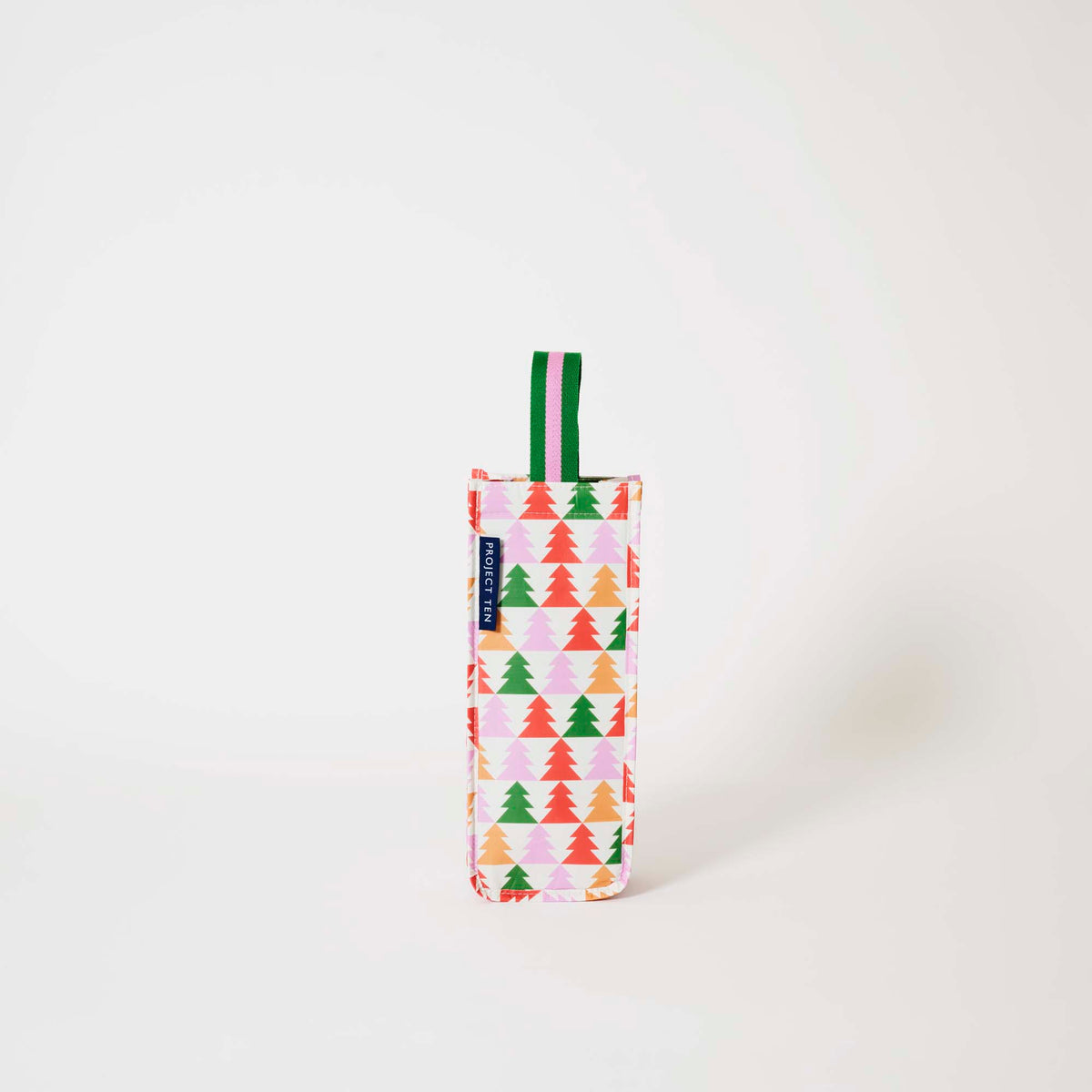 Our Holiday Cheers Wine Bag, a tall narrow bottle bag in an ecru base with a repeating geometric Christmas tree print in red, green, pink and orange, with a single green and pink striped carry handle.