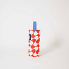 Our Red Ripple Wine Bag, a tall narrow bottle bag in a red and ecru wave print with a single blue carry handle.