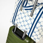 Zip Medium Tote in Navy Horseshoe sitting on a suitcase using the luggage band - Project Ten